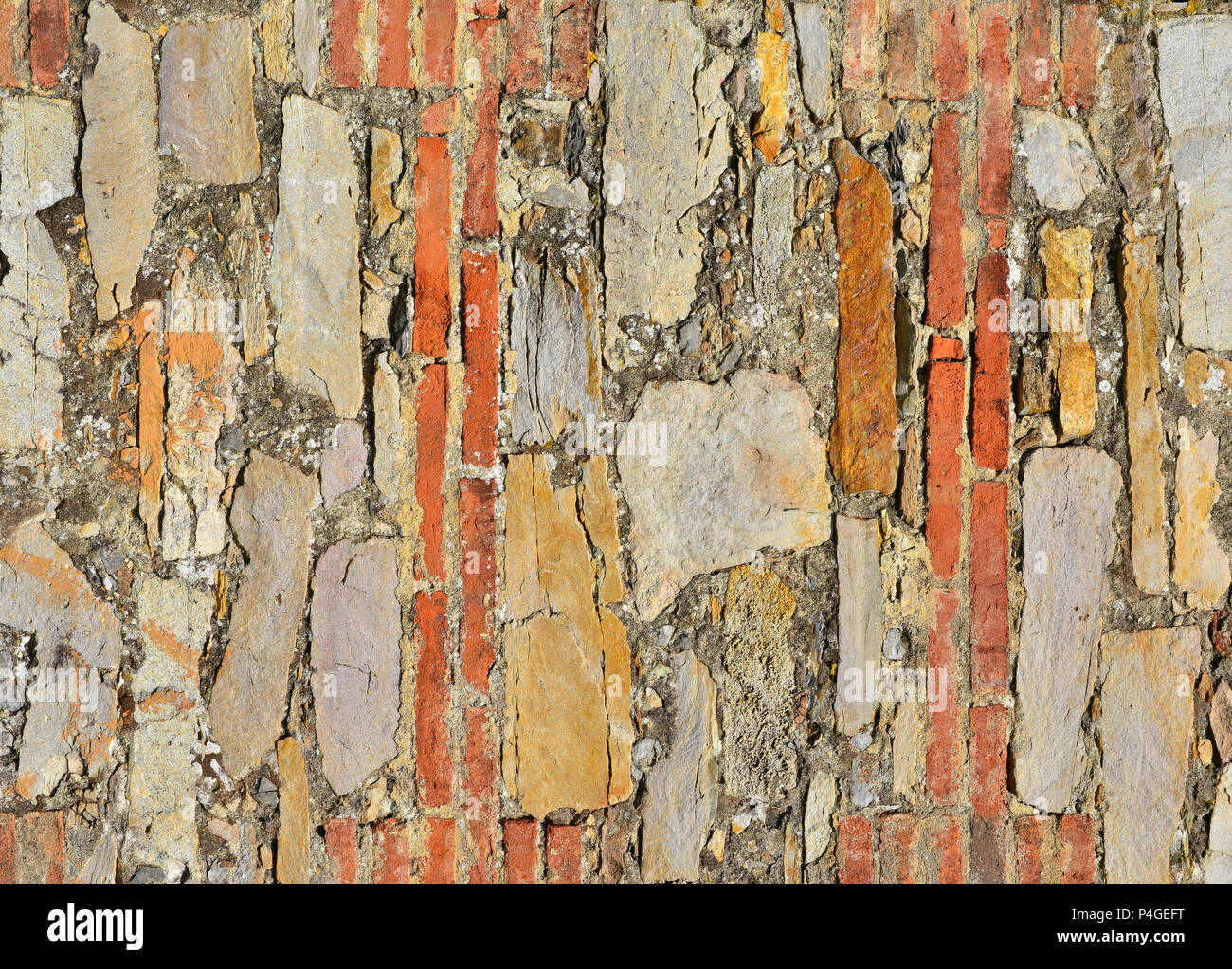 Alte Mauer mit Ziegel, Steine und Pflanzen als Hintergrund Stockfoto