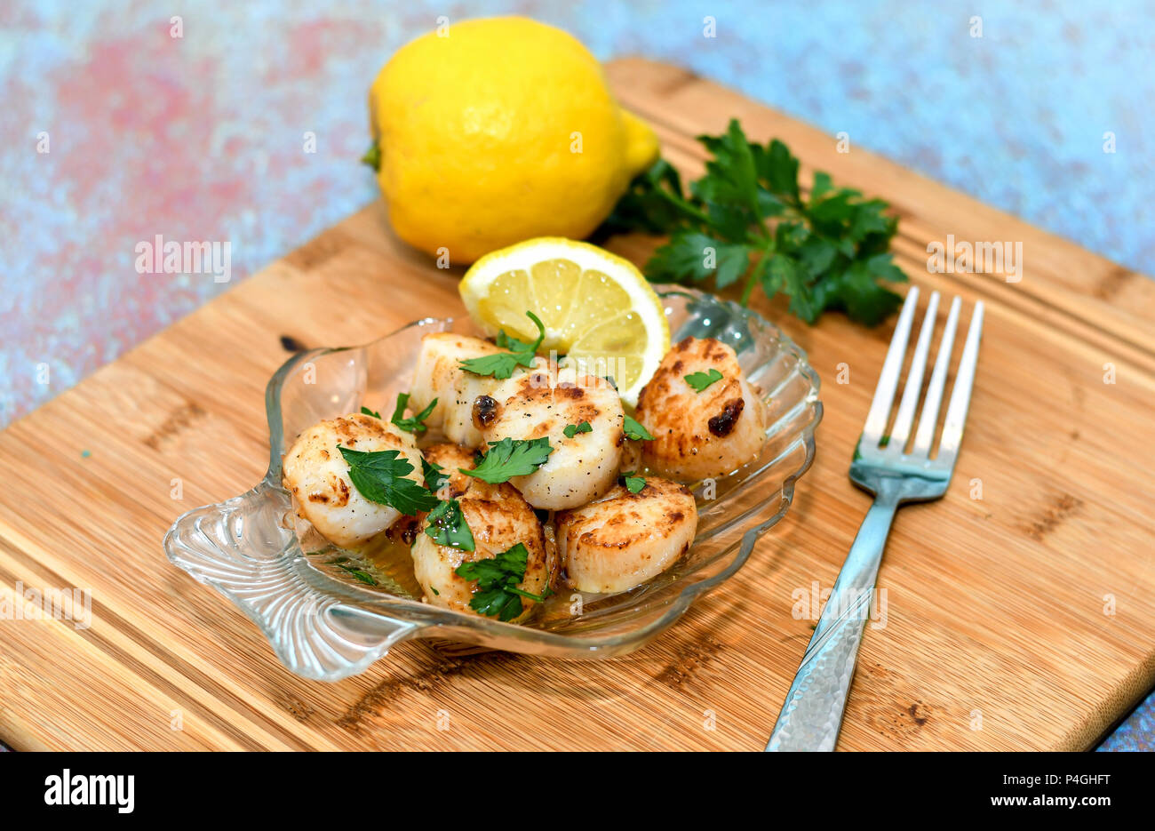 Glasplatte leckere Jakobsmuscheln mit Zitrone Butter Stockfoto