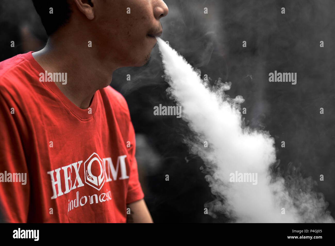 Elektronische Zigarette Benutzer ausatmet Dampf während einer vaping Messe in Jakarta, Indonesien. Stockfoto