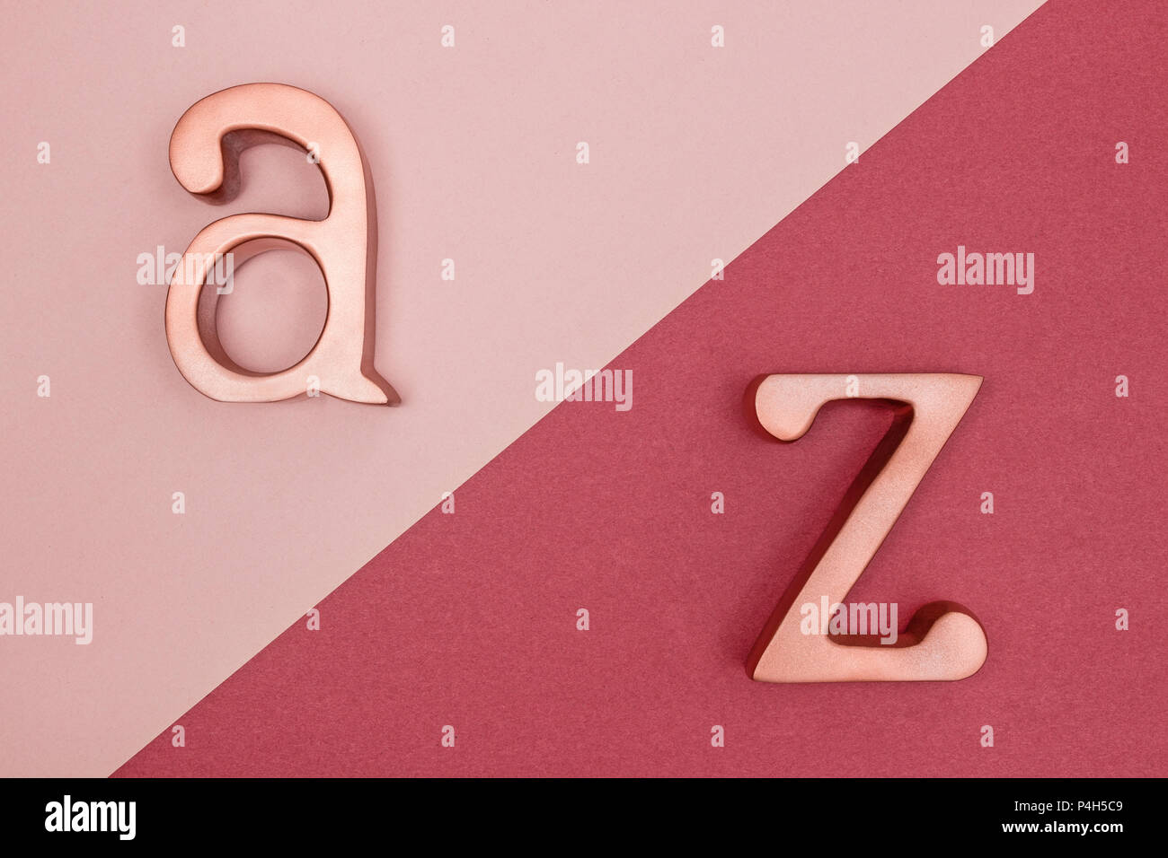 Metall Rose Gold Buchstaben A und Z auf pink und kirschrot Hintergrund. Stockfoto