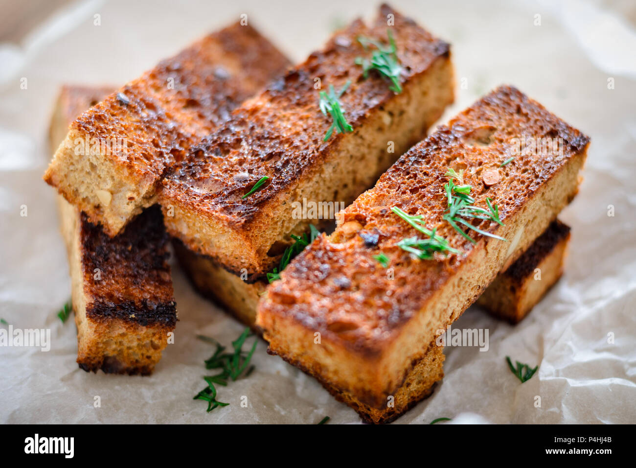 Appetitlich getoastetes Toast von Roggenbrot mit Dill auf weißem Hintergrund. Close-up Stockfoto