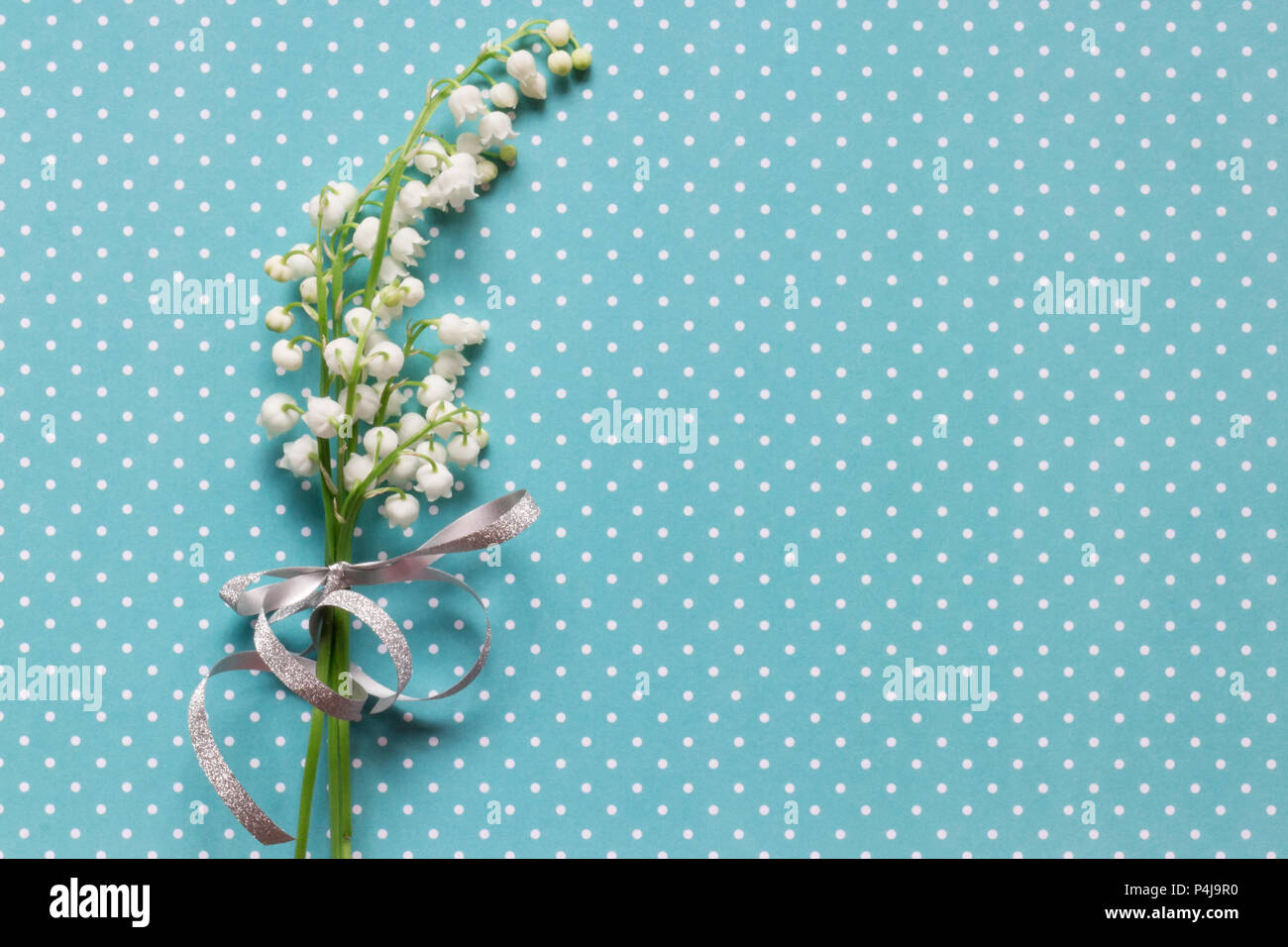 Lilly von Valley auf blau gepunkteten Muster Hintergrund Stockfoto