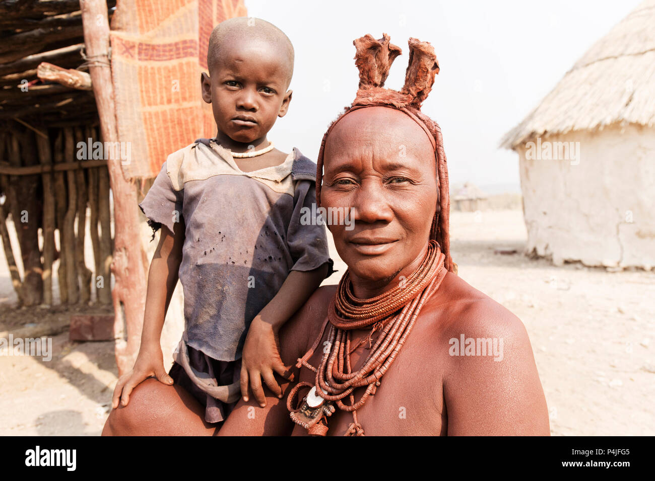 Himba Frau mit ihrem kleinen Sohn lächelnd in die Kamera im Dorf Himba Volk Stockfoto