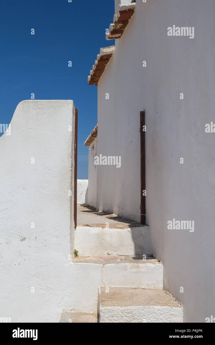 Weiße Farbe der Fassade der Kirche Nossa Senhora da Rocha in Porches, Algarve, Portugal. Rand des Daches. Strahlend blauen Himmel. Stockfoto