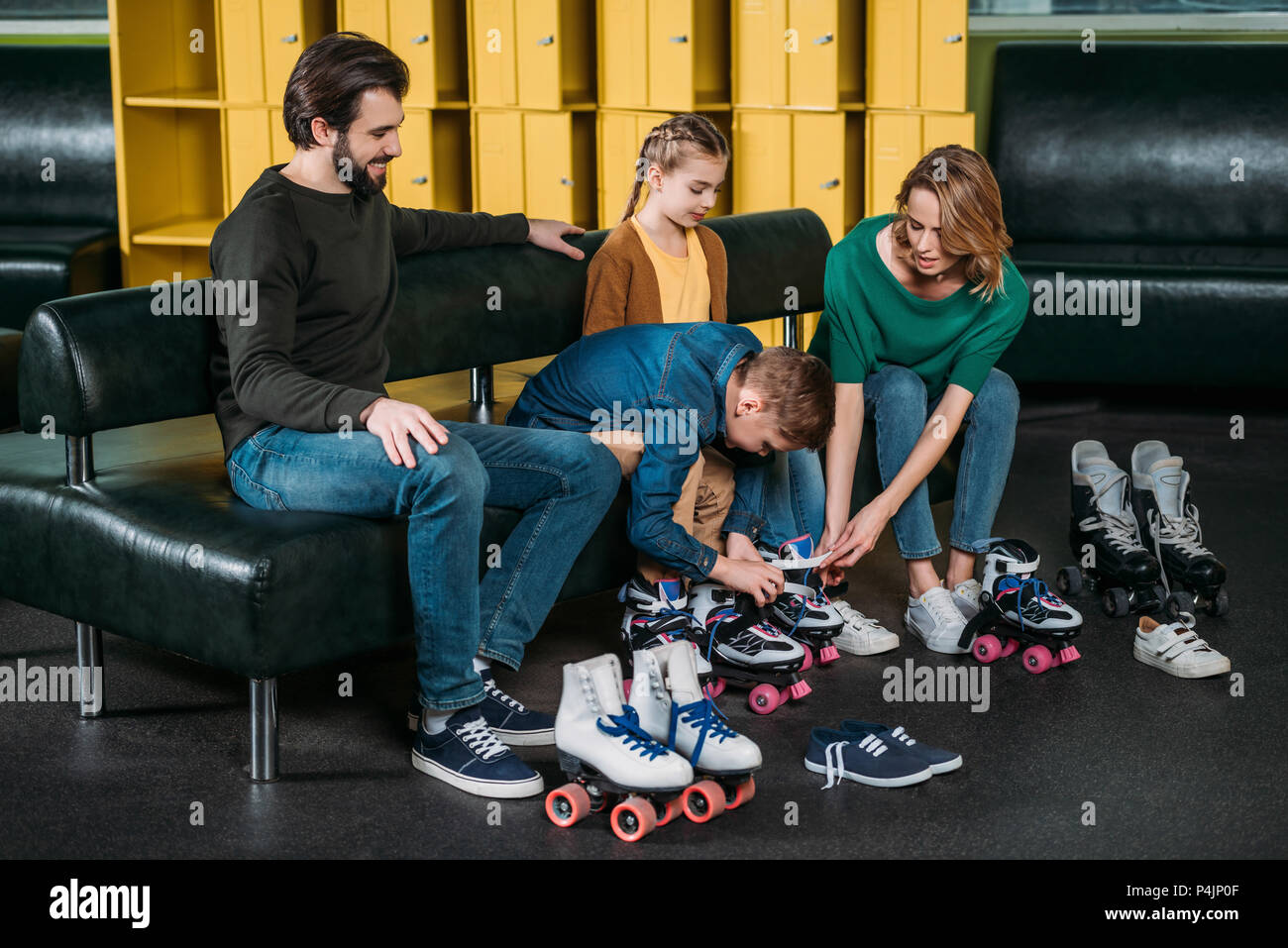 Familie tragen Rollschuhe vor Skaten in Skate Park Stockfoto