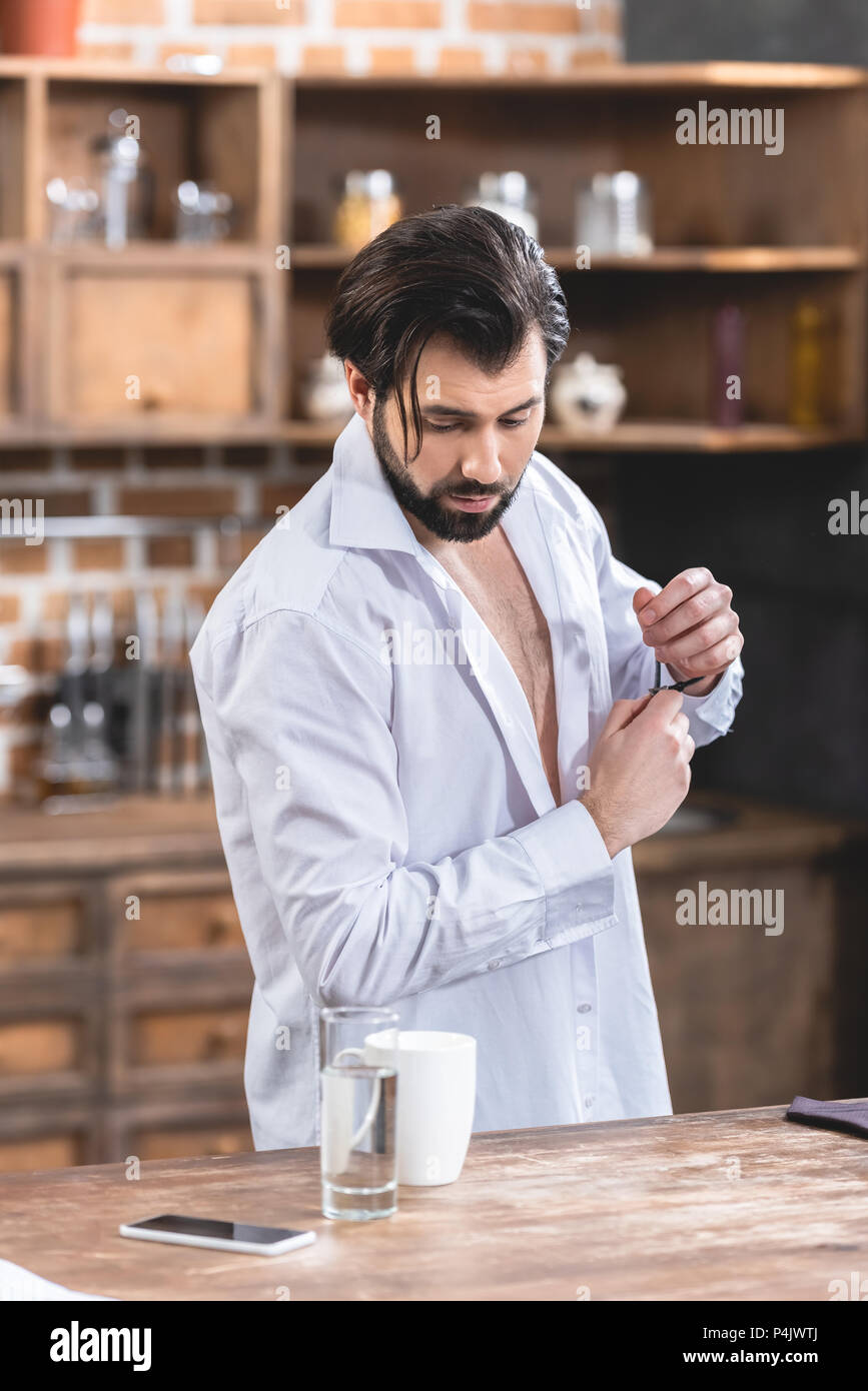 Stattliche Einzelgänger Geschäftsmann mit Aufgeknöpfte Hemd hinunter in Küche Stockfoto