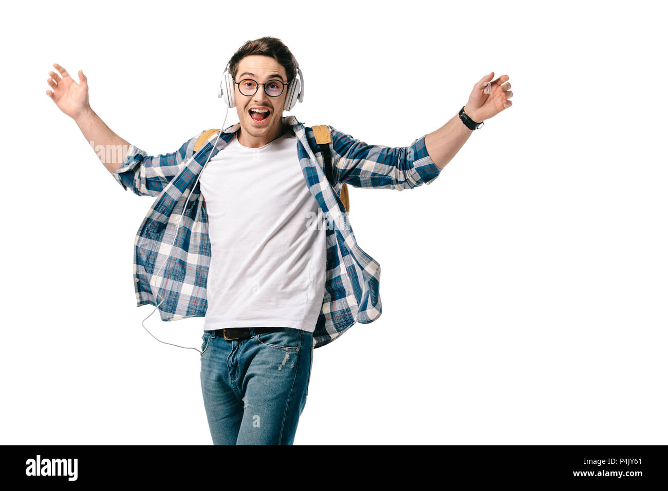 Lächelnd gut aussehender student Musik hören und tanzen isoliert auf weißem Stockfoto