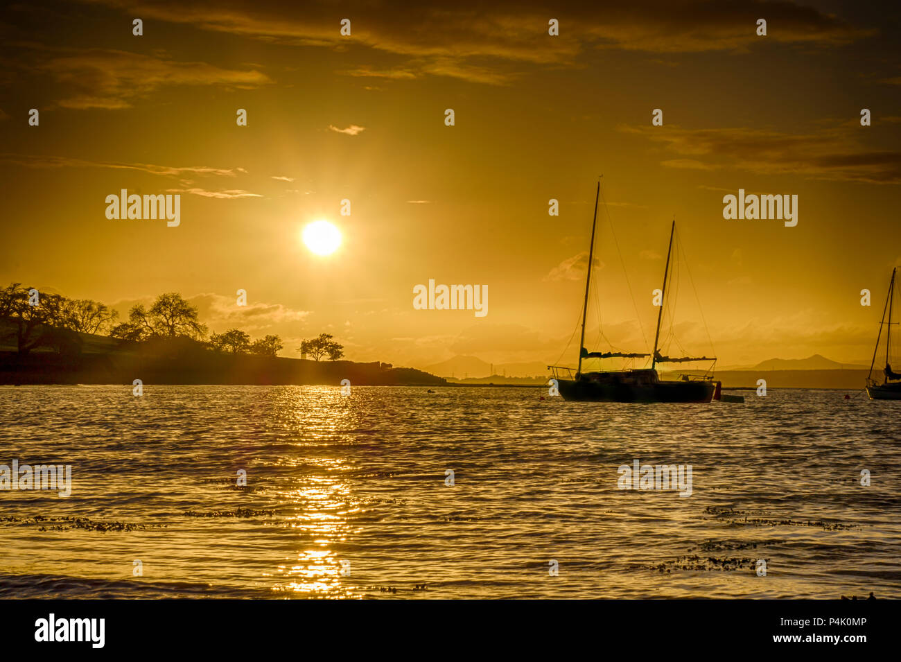 Die Sonne über Blackness Bay, West Lothian, Schottland. Stockfoto