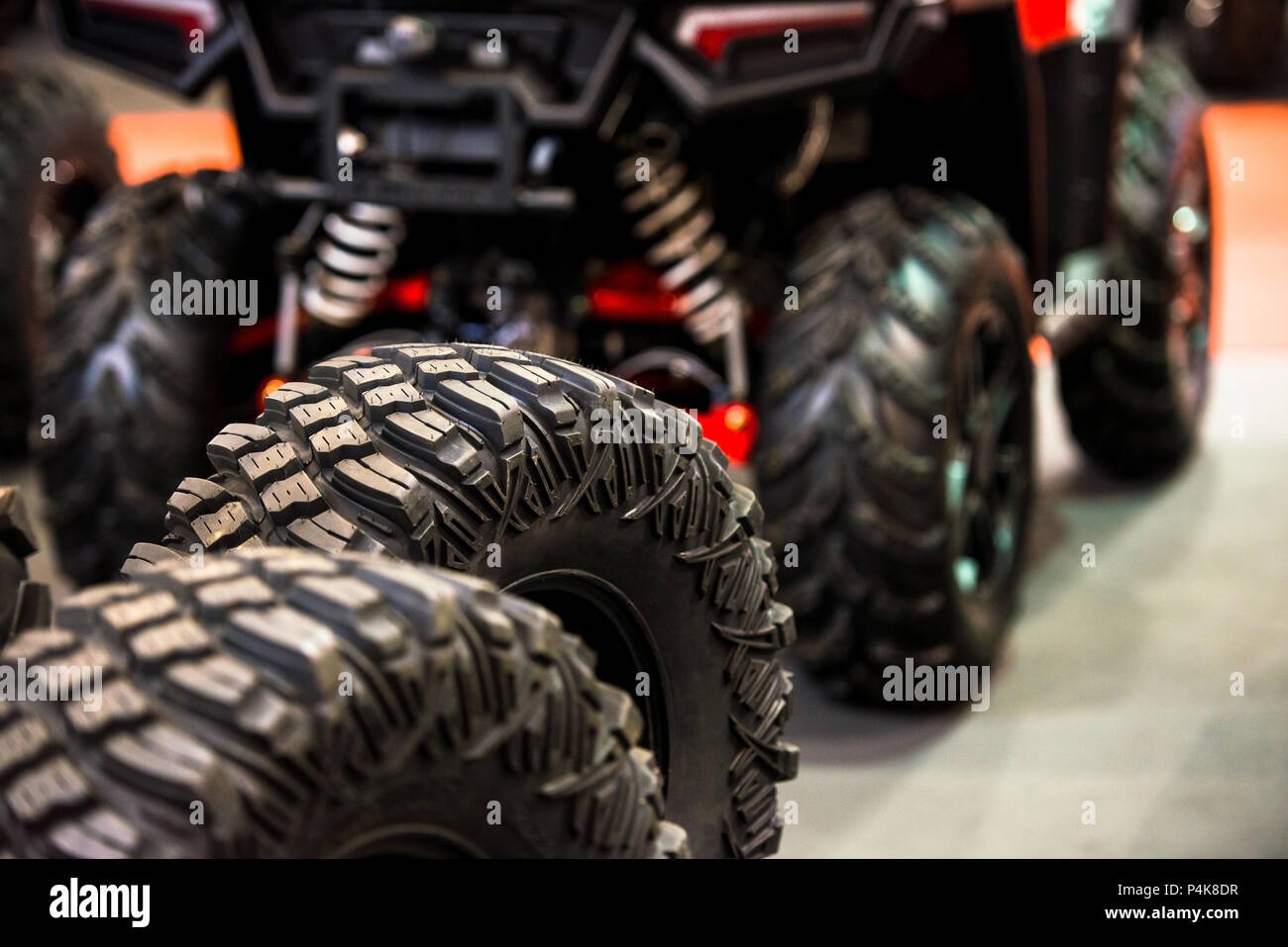 Reifen für Quad Bike mit verschwommenen Quad (vier Wheeler, quadricycle oder All-terrain vehicle) im Hintergrund Stockfoto