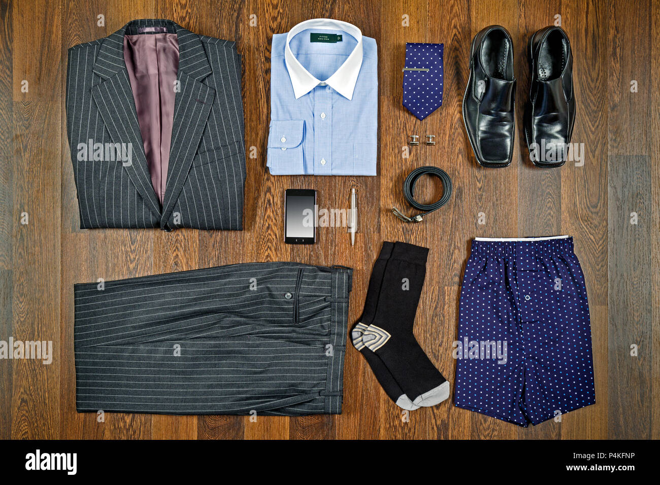 Ein flach Anordnung der mens Geschäftskleidung mit grau-gestreiften Anzug, weisses Shirt, schwarze Schuhe und passende Accessoires. Stockfoto