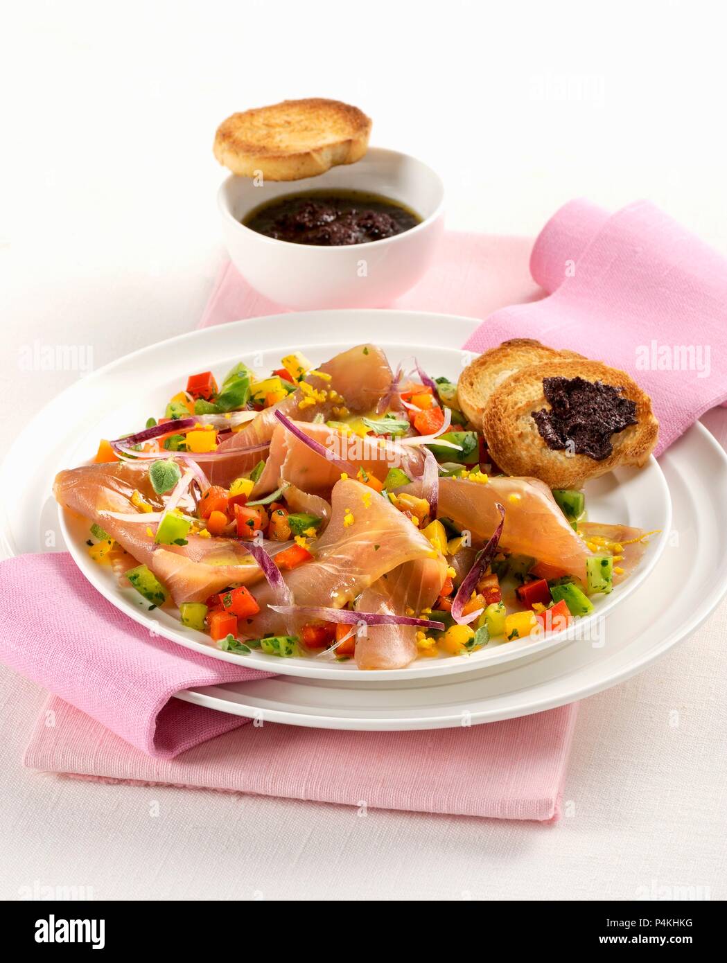 Geräucherter Thunfisch mit Frühlingszwiebeln und Paprika mit Crostini mit Olivenöl Sahne serviert. Stockfoto