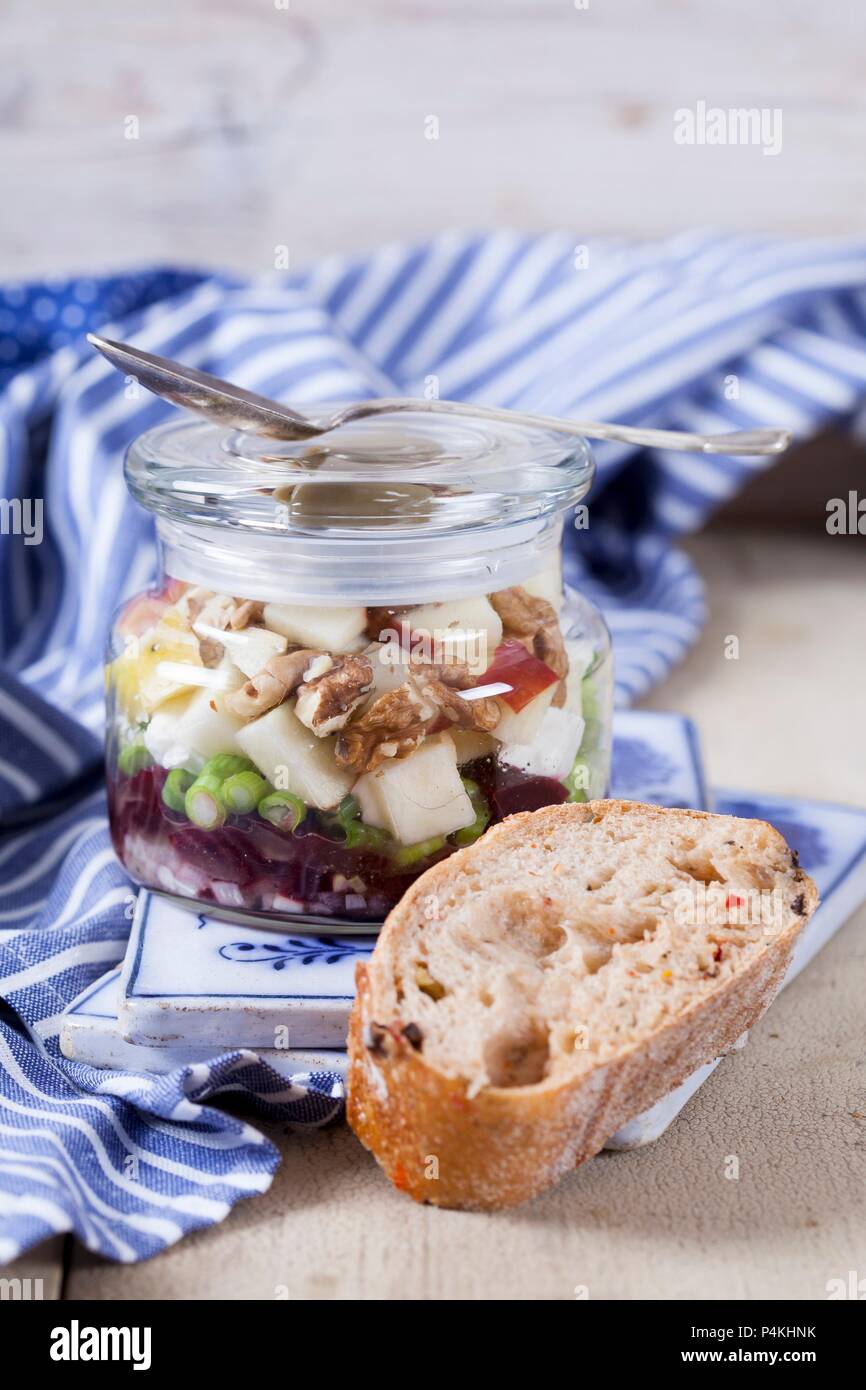 Rote Bete mit Ziegenkäse, Apfel, Nüsse, Oliven und Zwiebeln in einem Glas Stockfoto
