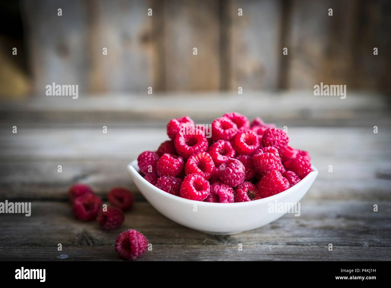 Eine Schale mit frischen Himbeeren auf einer rustikalen Holzmöbeln Oberfläche Stockfoto