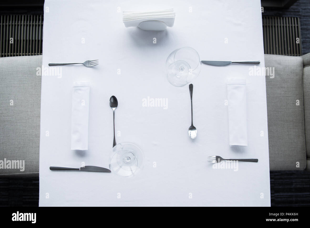 Ansicht von oben angeordnet, Besteck und Weingläser auf Tisch mit weißer Tischdecke im Restaurant Stockfoto
