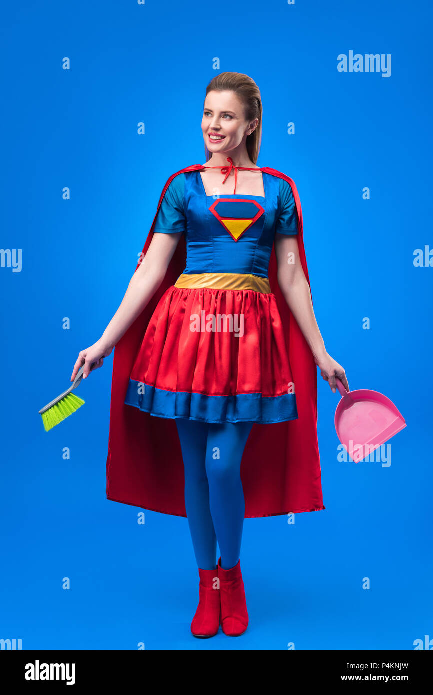 Frau in Superhelden Kostüm mit Besen und Schaufel für Reinigung isoliert  auf Blau Stockfotografie - Alamy