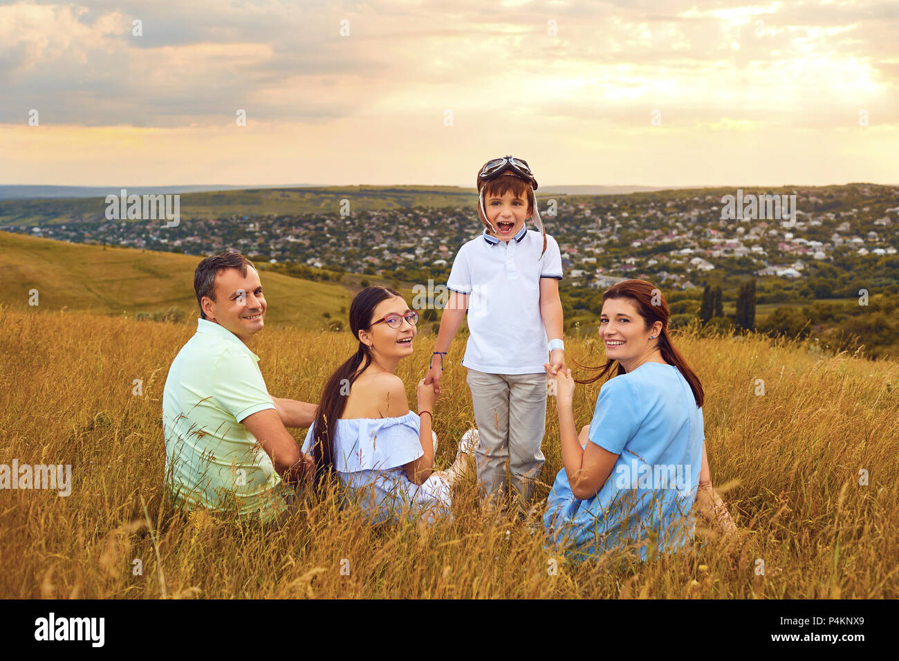 Porträt einer Familie sitzt lächelnd in der Natur Stockfoto