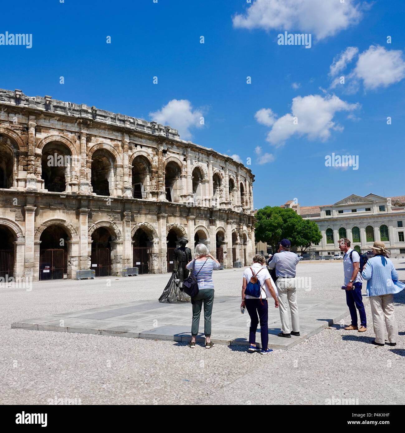 Touristen fotografieren Matador Statue vor dem römischen Amphitheater Arena gebaut über AD 70, Nîmes, Frankreich Stockfoto