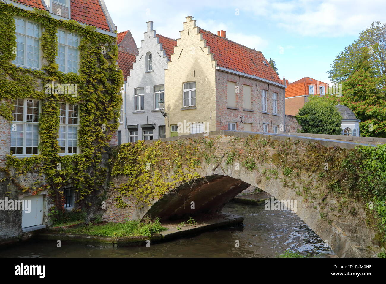 Traditionelles Haus Fassaden und eine mittelalterliche Brücke auf Peerdenstraat entlang der Grünen Kanal in Brügge, Belgien. Stockfoto