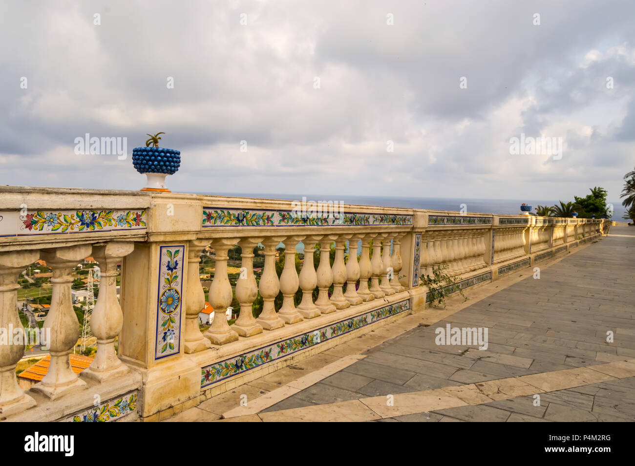 Geschnitzte Handlauf mit Keramik Muster und durch einen blauen Becken mit einem Kaktus in der Stadt Santo Stefano di Camastra im Norden Sizilien überwunden Stockfoto