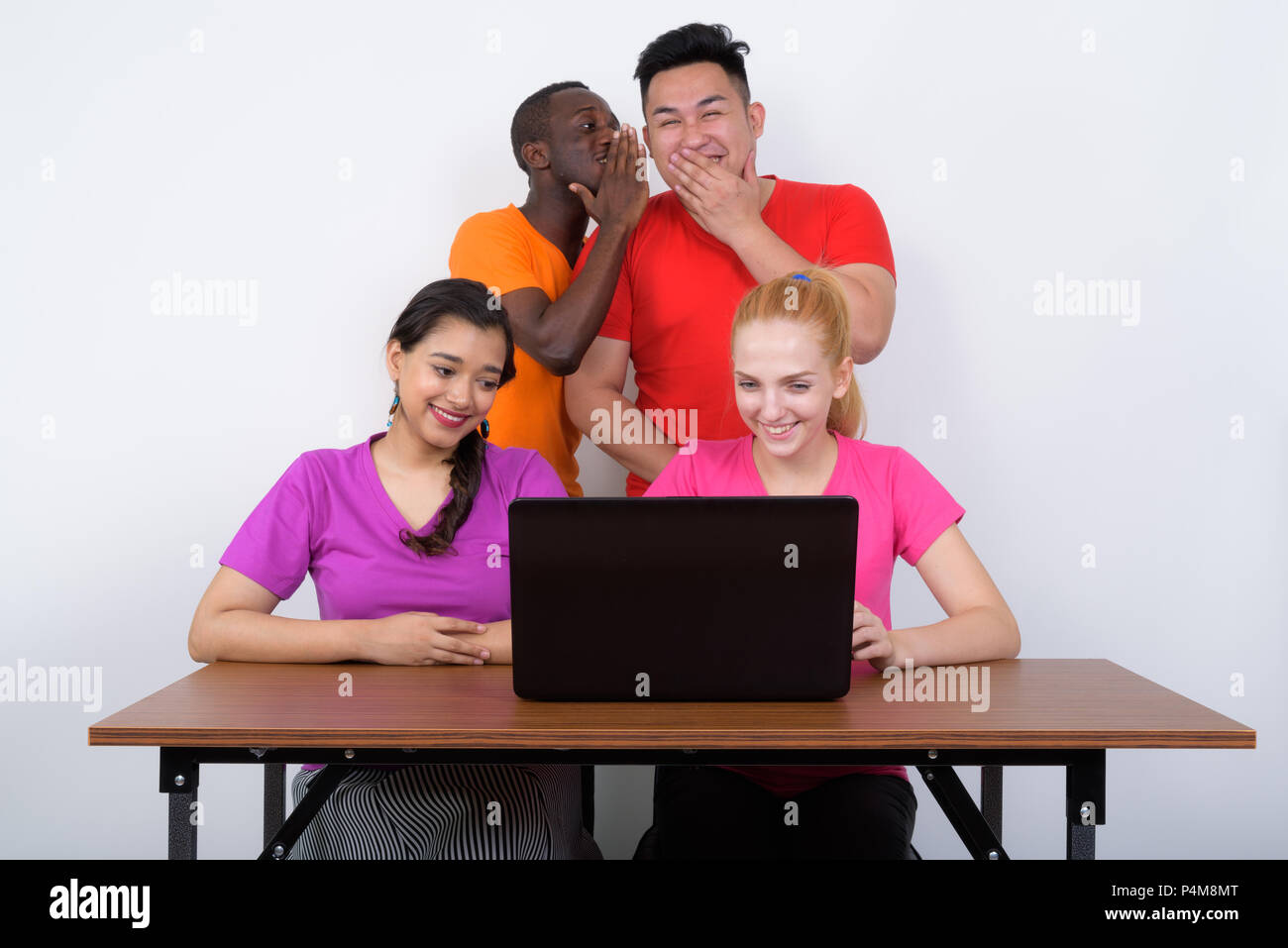 Gerne vielfältige Gruppe von multi-ethnische Freunde lächelnd während der Verwendung Stockfoto