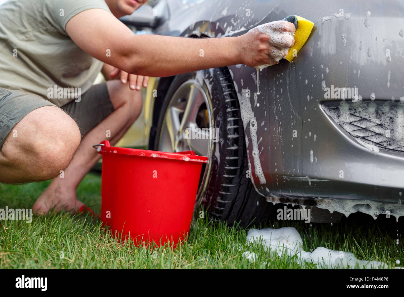 Schwamm und Eimer - Junger Mann sein Auto waschen Stockfotografie - Alamy