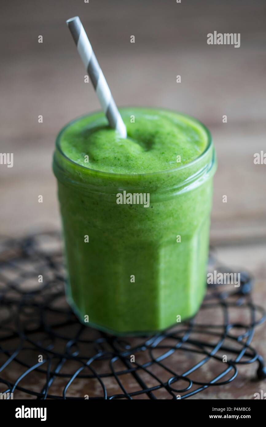 Ein grünes Smoothie in einem Glas mit Schraubverschluss mit Strohhalm Stockfoto