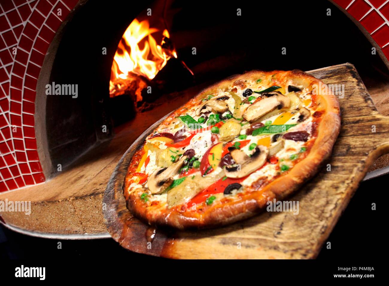 Pizza mit Champignons und Zucchini aus dem Holzofen Stockfoto