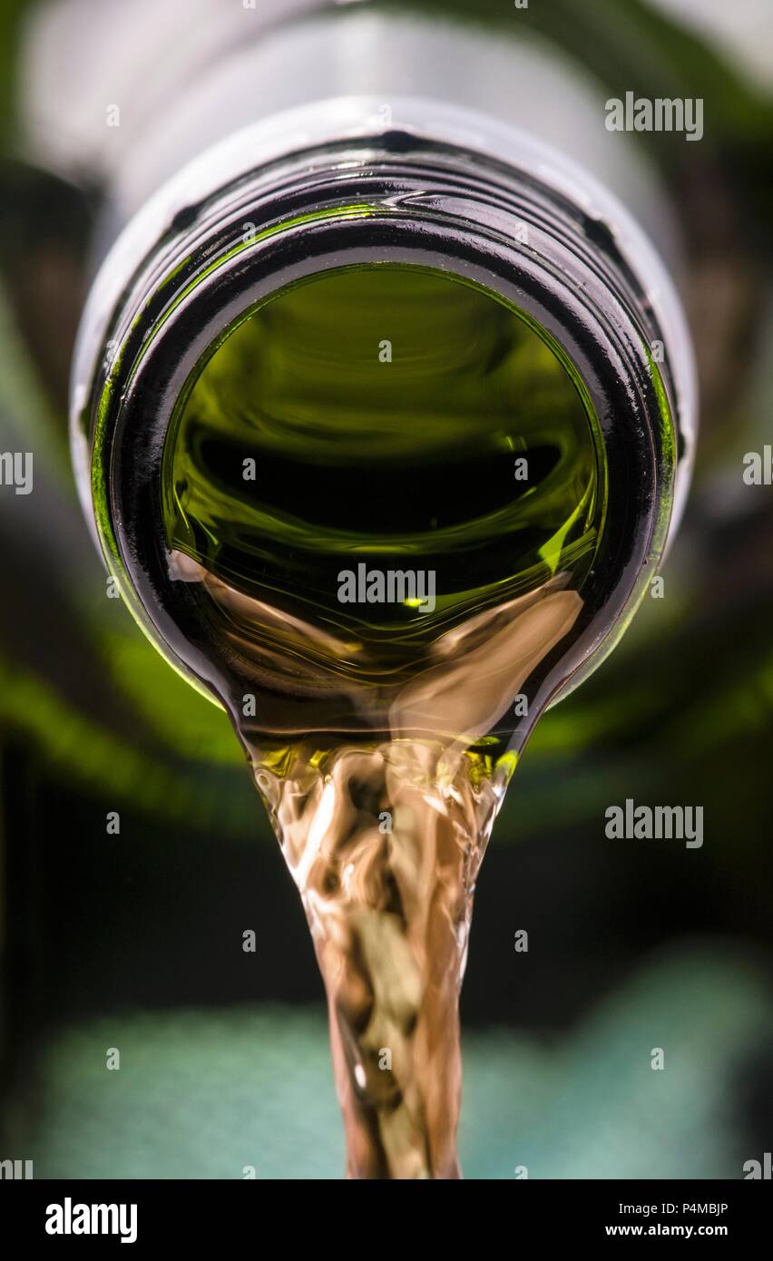 Weißwein wird von einer Flasche ausgegossen Stockfoto