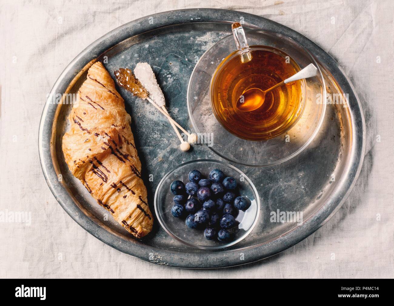 Eine Tasse Kaffee, Croissants und Heidelbeeren auf eine altmodische Fach Stockfoto