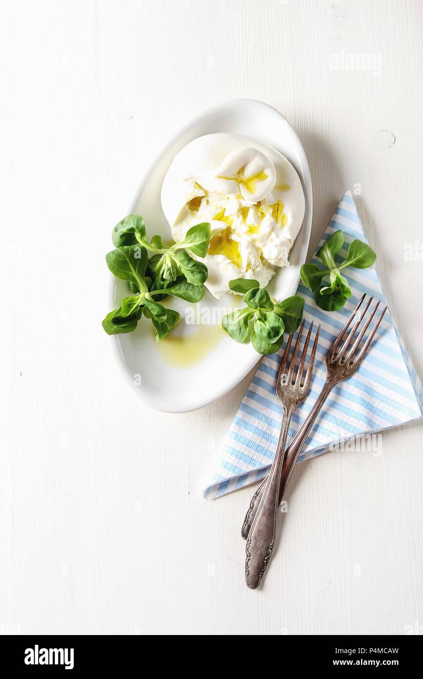 Italienische frische burrata Käse in einem keramischen Brei mit grünem Salat Stockfoto