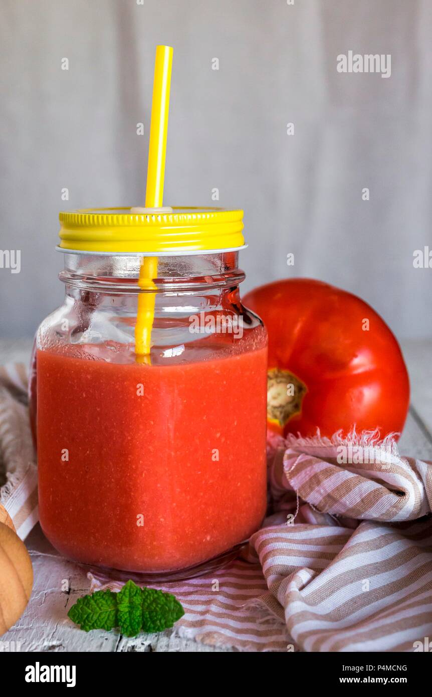 Kalte Tomatensuppe in einem Glas mit Schraubverschluss mit einem Deckel und einem Stroh Stockfoto