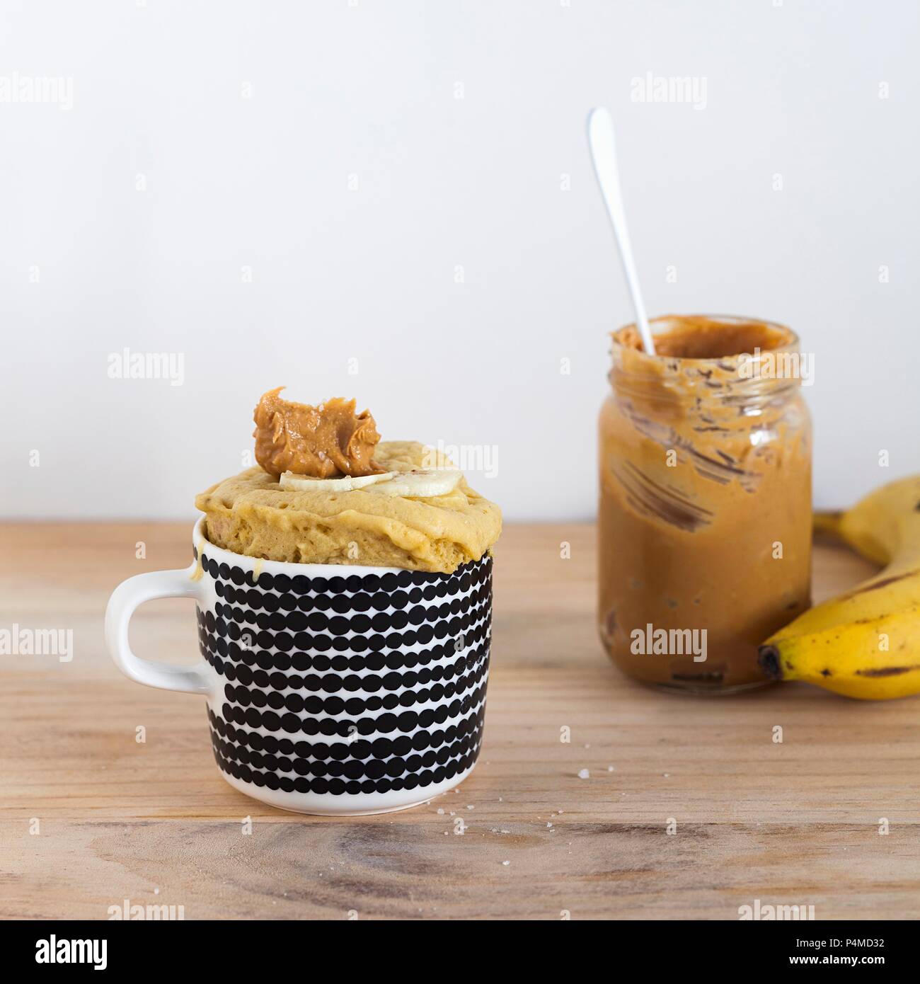 Bananenbrot Becher Kuchen mit ein Glas Erdnussbutter Stockfoto