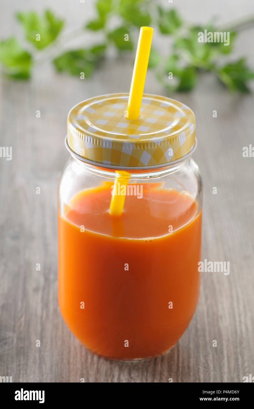 Karottensaft in einem Glas mit Schraubverschluss mit Strohhalm Stockfoto