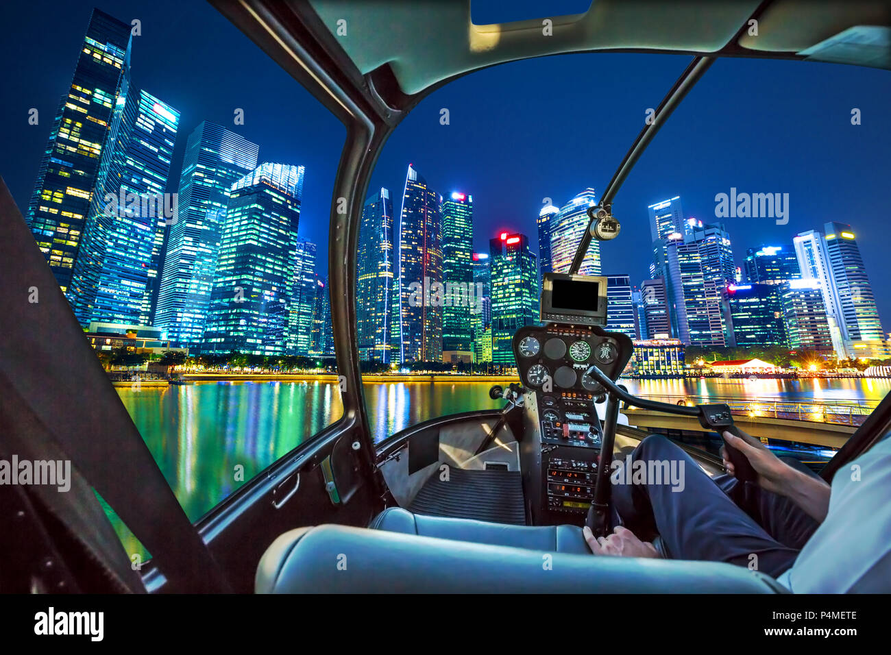 Helicopter Cockpit Innenraum fliegen auf dem zentralen Geschäftsviertel von Marina Bay Waterfront Promenade an der bayfront South Jetty. Singapur Skyline bei Nacht beleuchtet. Stockfoto