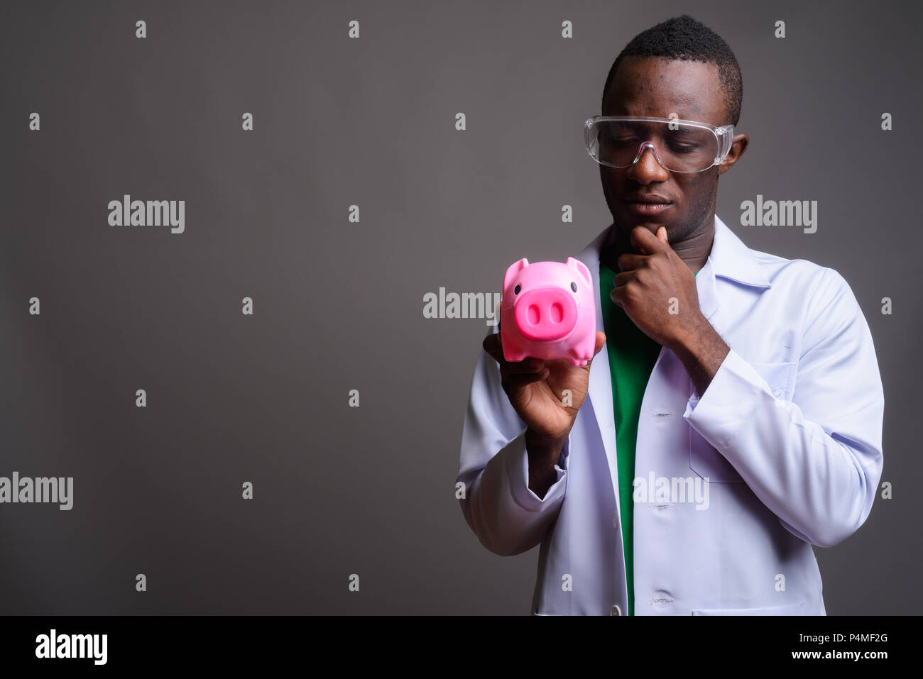 Junge afrikanische Mann Arzt tragen Schutzbrille gegen Grau Stockfoto