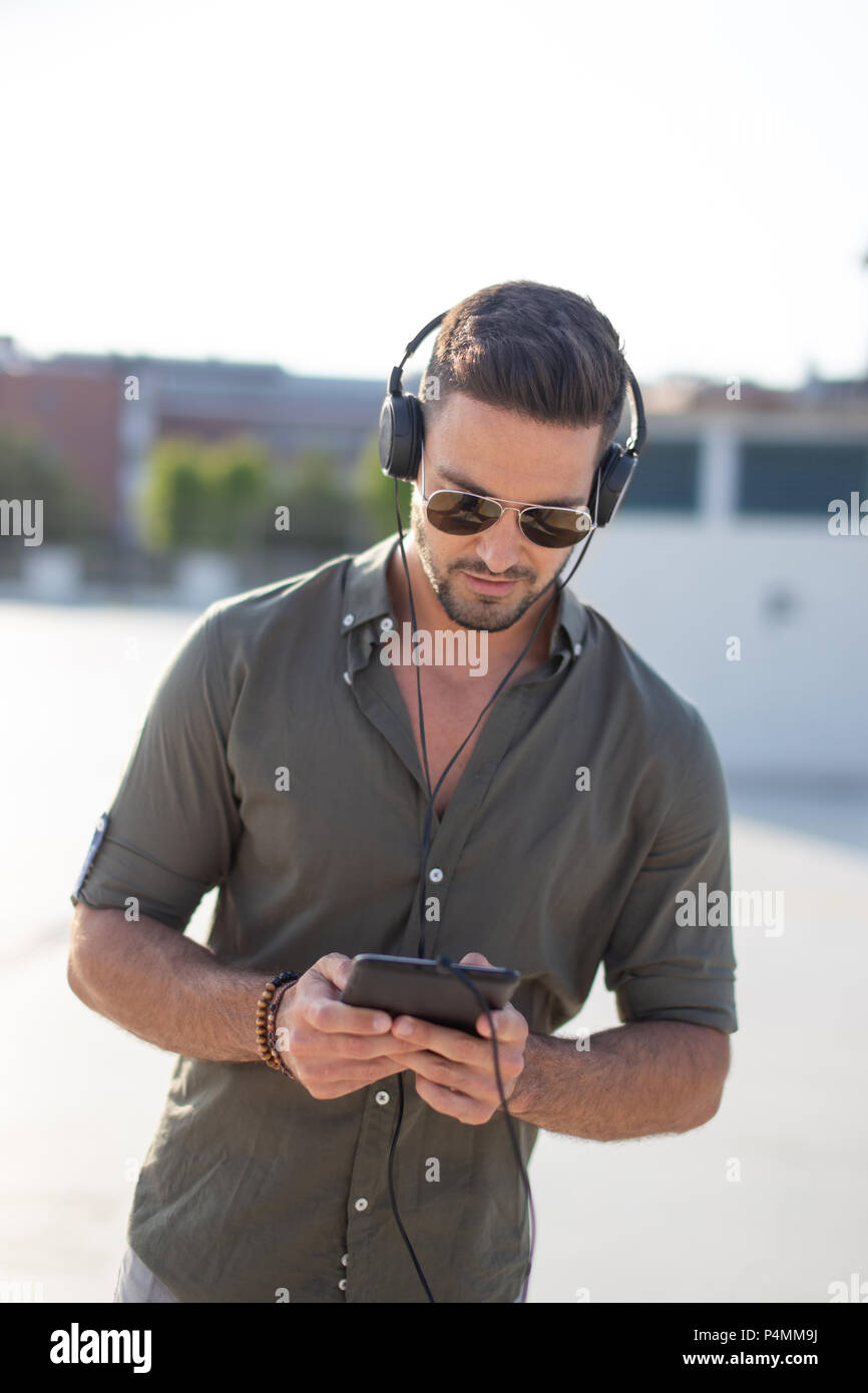 Jungen kaukasischen Mann hören Musik im Freien Stockfoto