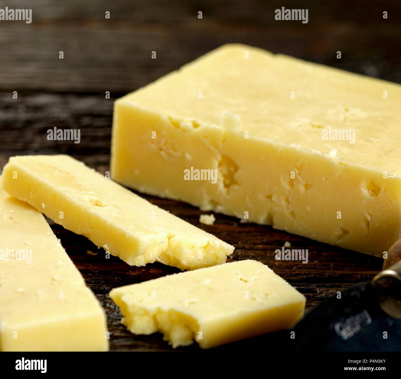 Cheddar Käse auf dunklem Holz Stockfoto