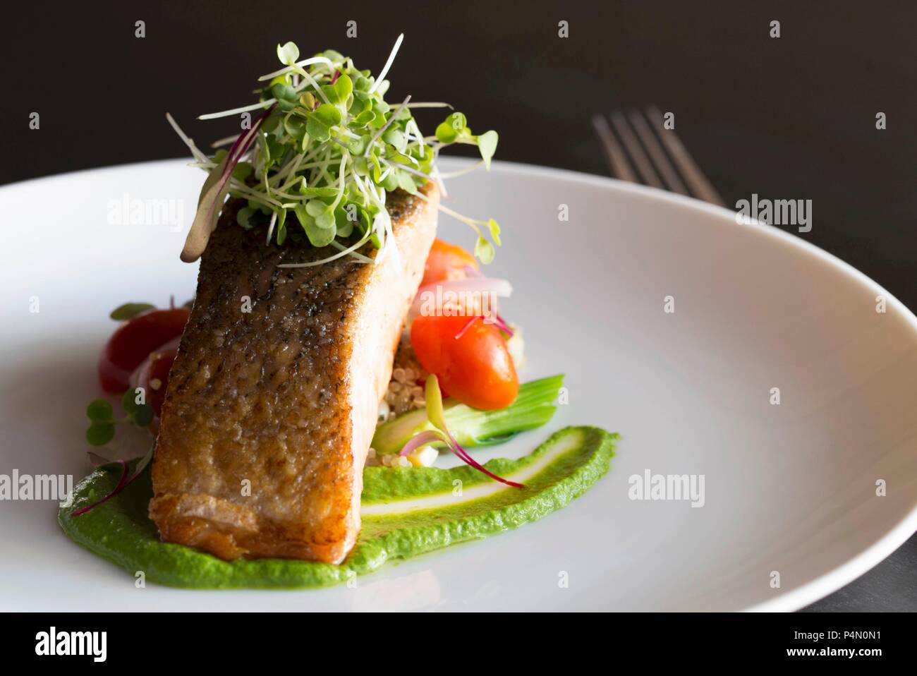 Gegrillter Lachs mit Rucola pürieren und mit Tomaten und Mais Salat Stockfoto