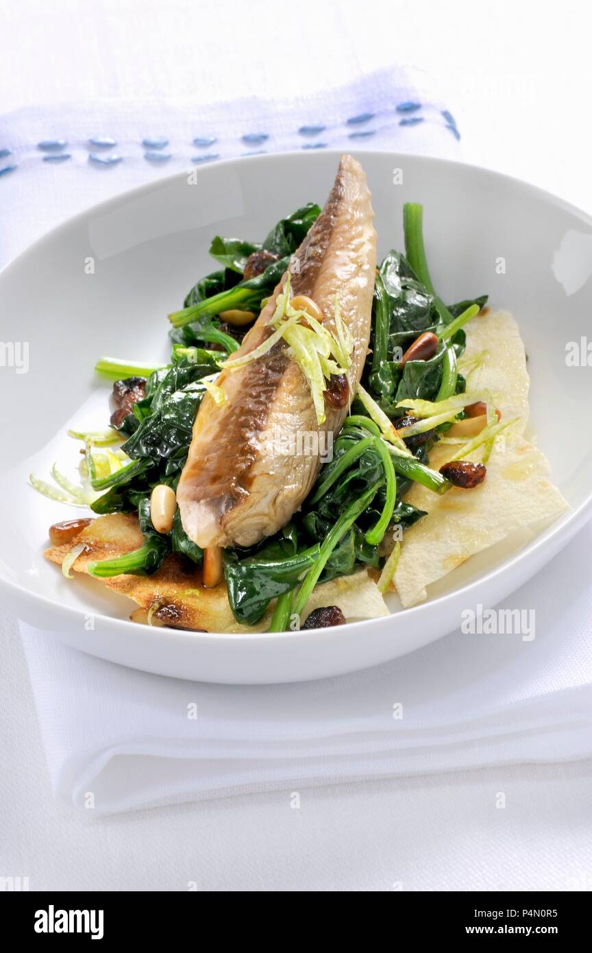 Sgombro con spinaci e Bereich carasau (Makrele mit Spinat auf einer Scheibe Brot, Italien) Stockfoto