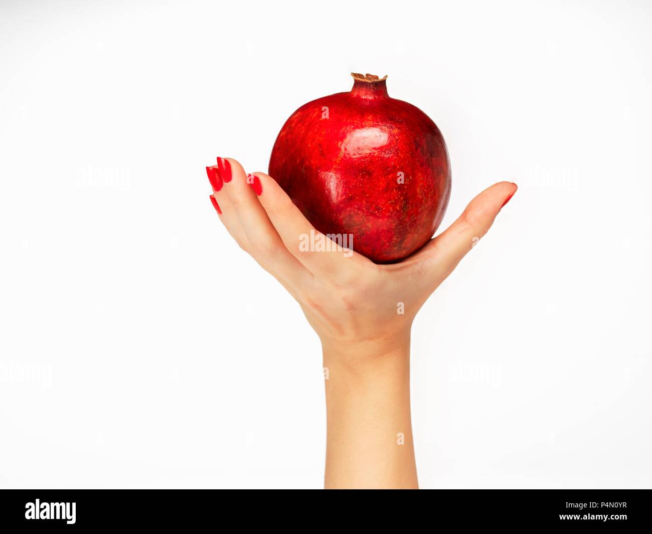 Einer Frau, die Hand mit einem Granatapfel Stockfoto