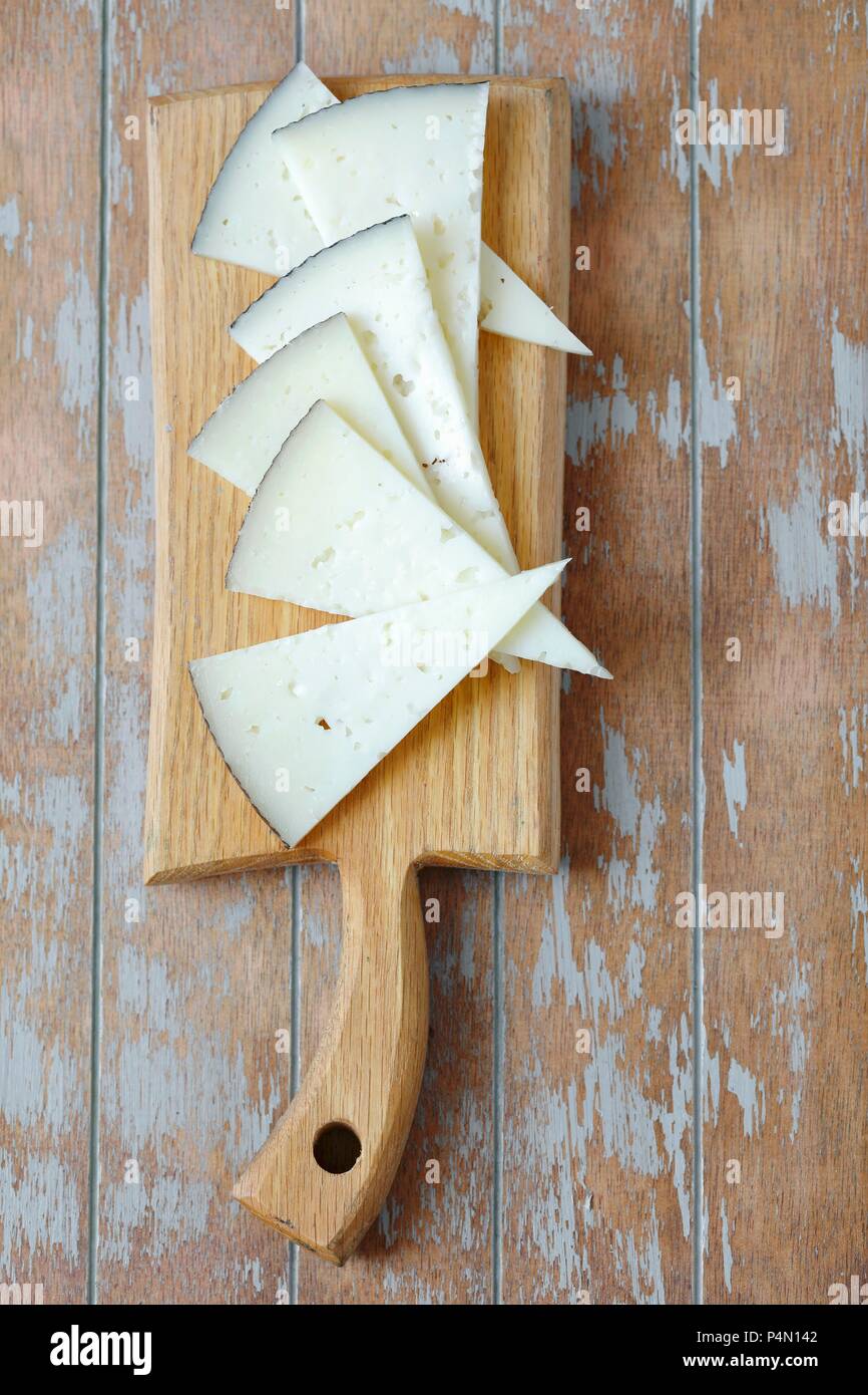 Dreiecke Manchego Käse auf einem Schneidebrett (von oben gesehen) Stockfoto