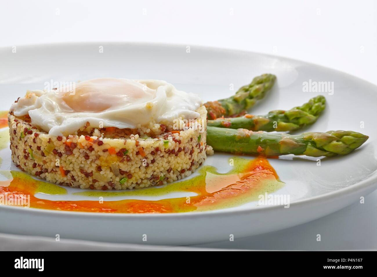 Quinoa Timbale mit Spiegelei und grünem Spargel Stockfoto