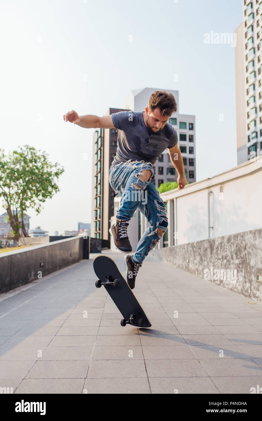 Skateboarder tun ein Skateboard trick Ollie auf der Straße einer Stadt Stockfoto