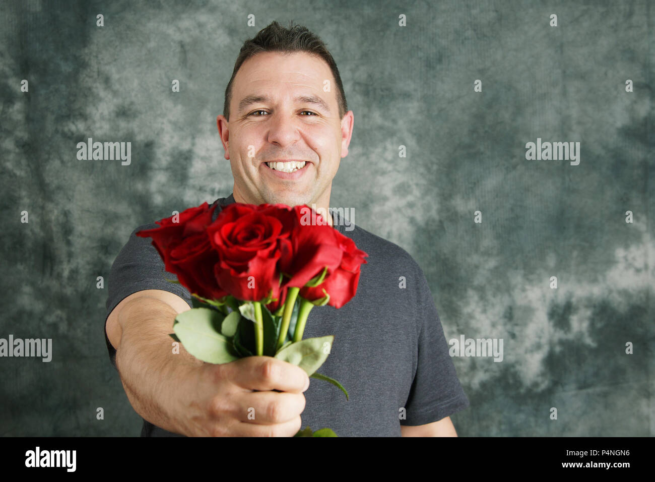 Romantischen Mann mit Blumenstrauß aus roten Rosen, glücklich Stockfoto