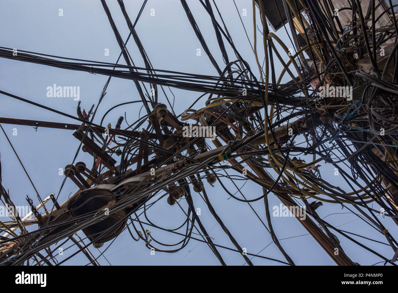 Drähte, die mit den elektrischen Stange befestigt, das Chaos der Kabel und Leitungen auf einem elektrischen Pol in Neu Dehli, Indien, Konzept der Elektrizität Stockfoto