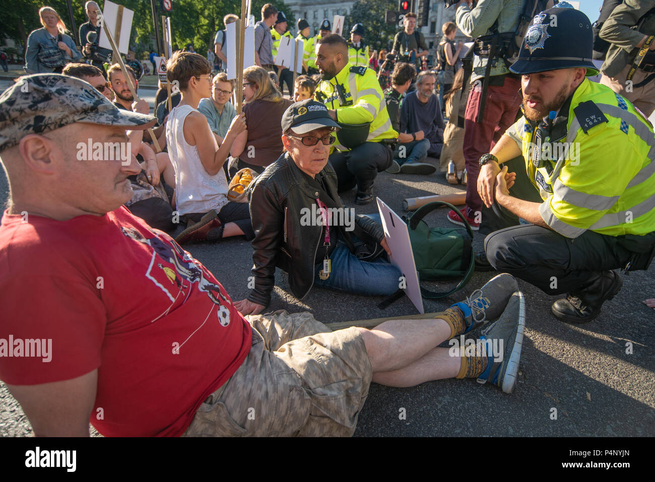 London, Großbritannien. Am 22. Juni 2018. Ein Polizeioffizier watns Mitkämpfer in der Straße sitzen im Parlament Squarea gegen die Erweiterung des Flughafens Heathrow, daß sie den Straftatbestand des Hindernisses von der Autobahn begehen und kann verhaftet werden. Sie waren nicht weiter dort für 30 Minuten zu sitzen beeindruckt und, einige Plakate gegen Heathrow Expansion. Die Teilnehmer enthalten einige, die im Hungerstreik außerhalb der Labour Party HQ für 14 Tage so weit gewesen. Credit: Peter Marschall/Alamy leben Nachrichten Stockfoto