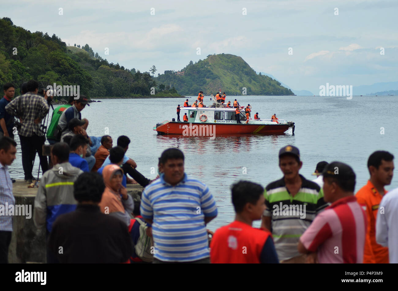 Medan, Indonesien. Am 22. Juni 2018. Die Einheimischen beobachten Sie das SAR-Team, die auf der Suche nach Menschen, die ins Ausland der gemeldeten Boot kentern in Lake Toba. Die Suche benutzt ein Schiff, an denen Taucher und die Hilfe von Sensor tools. Bereits am 18. Juni 2018, ein Boot kentern in den Gewässern des Lake Toba wegen schlechten Wetters mit 190 Touristen im Ausland. Credit: SOPA Images Limited/Alamy leben Nachrichten Stockfoto