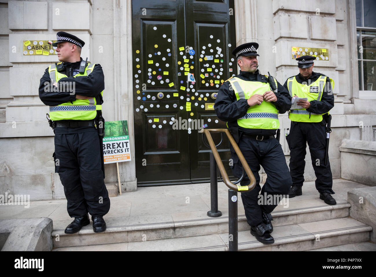 London, Großbritannien. 23. Juni 2018. Polizisten bewachen die vordere Tür des Cabinet Office aus mehr defacement mit Aufklebern von bleiben Unterstützer und die Demonstranten zu einem Anti-Brexit März und Sammlung für die Volksabstimmung. Foto: Bettina Strenske/Alamy leben Nachrichten Stockfoto