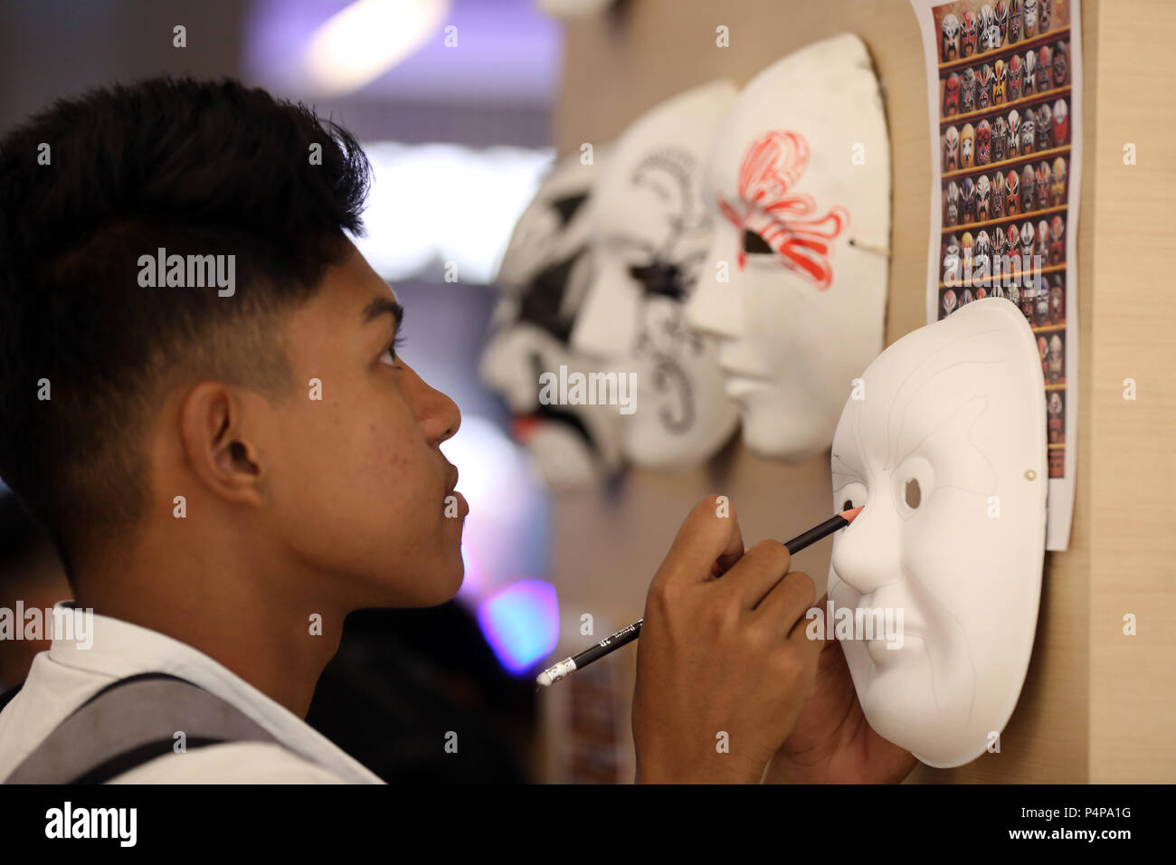 Yangon, traditionelle Chinesische Kleid Foto-op und Tee kunst Anzeige und Retail wurden bei der Veranstaltung durchgeführt. 23. Juni 2018. Ein Besucher zeichnet Linien auf einer Gesichtsmaske während einer chinesischen Kultur und Kunst zeigen in Yangon, Myanmar, 23. Juni 2018. Aktivitäten wie Kalligraphie, Chinesische Papier schneiden, Chinesischen verknoten, chinesische Maske malen, traditionelle Chinesische Kleid Foto-op und Tee kunst Anzeige und Retail wurden auf der Veranstaltung, die in Yangon am 23. Juni 2018 gehalten wurde. Credit: U Aung/Xinhua/Alamy leben Nachrichten Stockfoto