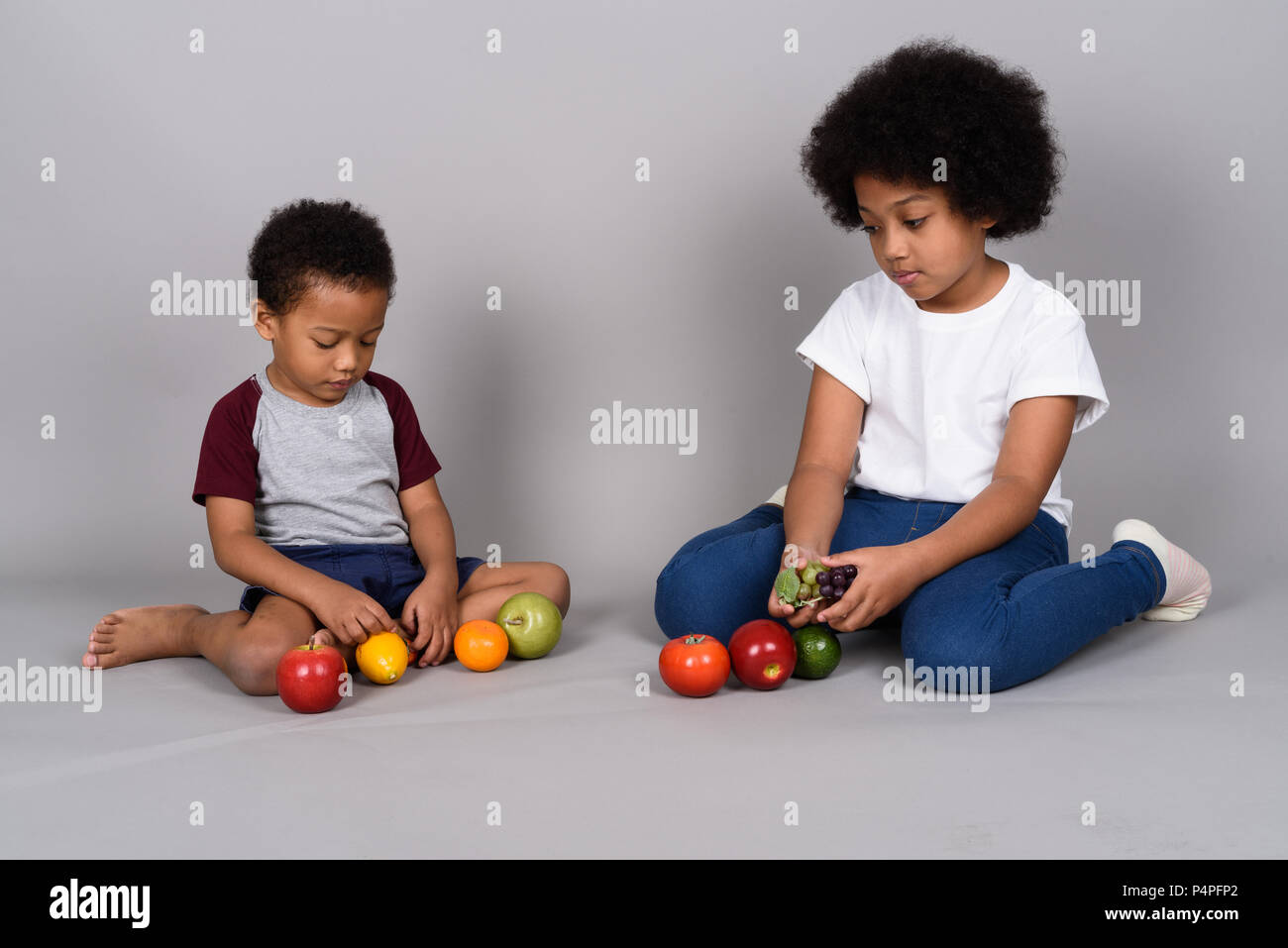 Junge niedlichen Afrikanischen Geschwister zusammen gegen grauer Hintergrund Stockfoto